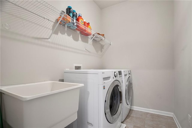 washroom featuring washing machine and dryer and baseboards
