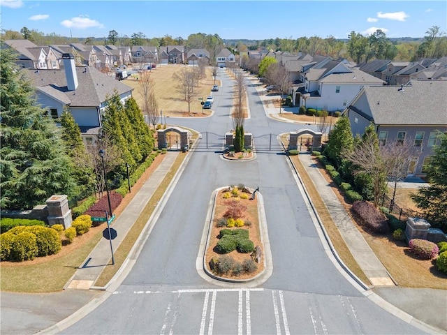 view of asphalt street with a residential view and curbs