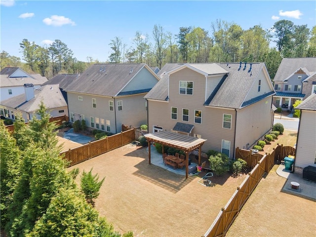 rear view of property featuring a residential view, a patio area, and a fenced backyard