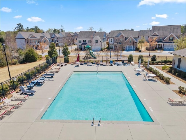 community pool featuring a residential view, fence, and a patio