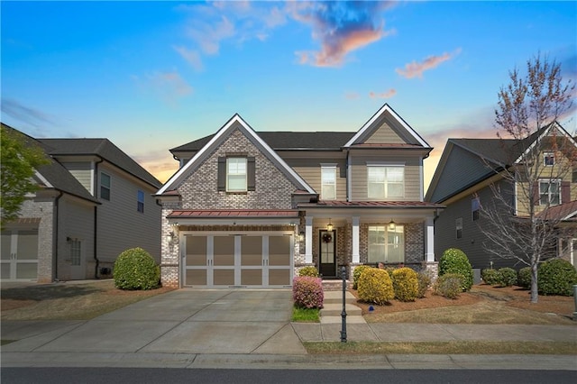 craftsman inspired home featuring brick siding, driveway, an attached garage, and covered porch