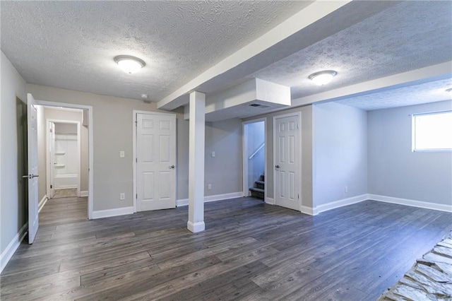 basement with a textured ceiling and dark hardwood / wood-style floors