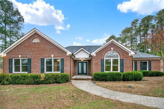 ranch-style home featuring a front yard, french doors, and brick siding