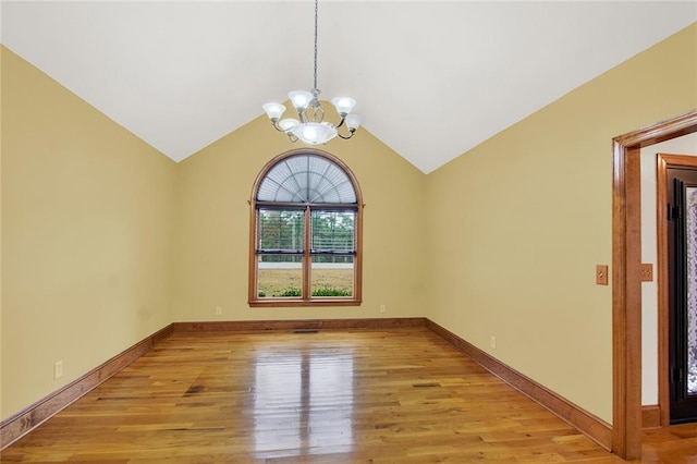 unfurnished room with lofted ceiling, an inviting chandelier, baseboards, and light wood-style floors