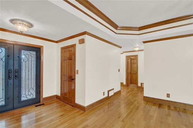 entrance foyer with baseboards, visible vents, crown molding, and light wood finished floors