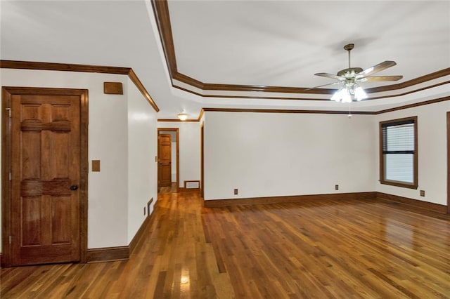 unfurnished room featuring ornamental molding, a raised ceiling, baseboards, and dark wood-style flooring