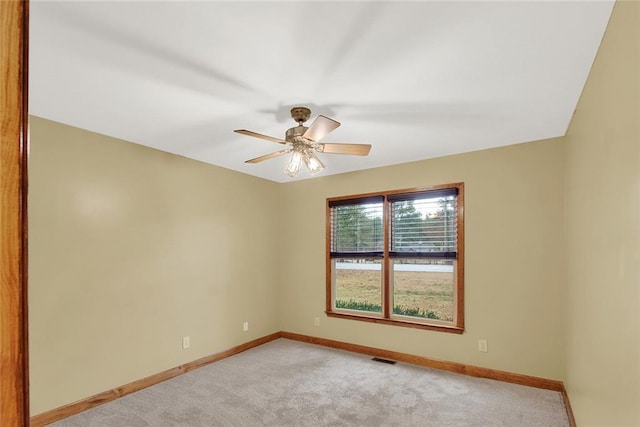 empty room with ceiling fan, visible vents, baseboards, and light colored carpet