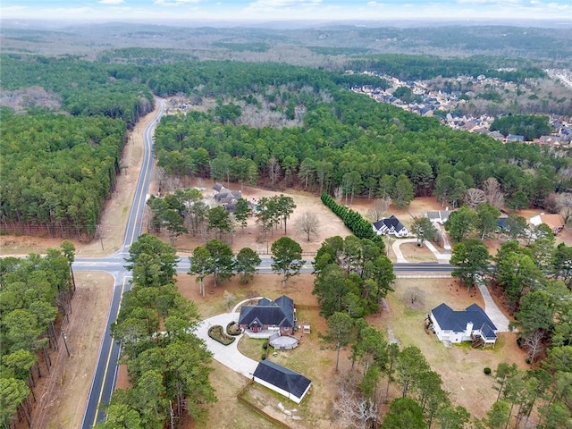 birds eye view of property featuring a forest view