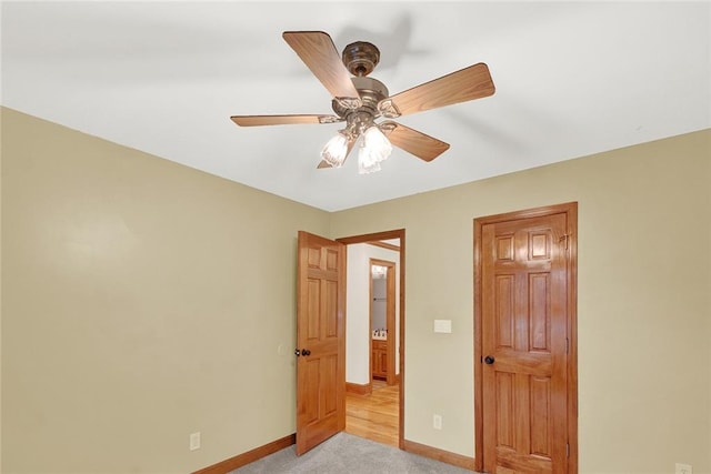 bedroom with a ceiling fan, light colored carpet, and baseboards