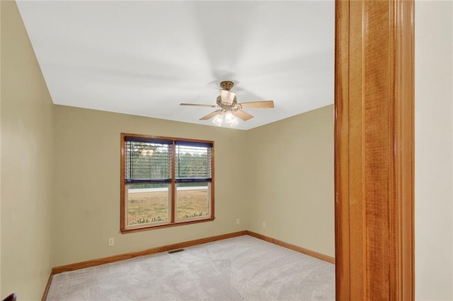 spare room featuring a ceiling fan, light carpet, visible vents, and baseboards