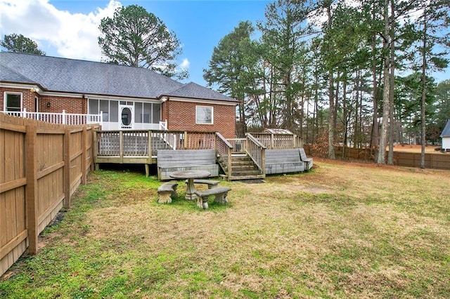 rear view of house with a deck and a yard