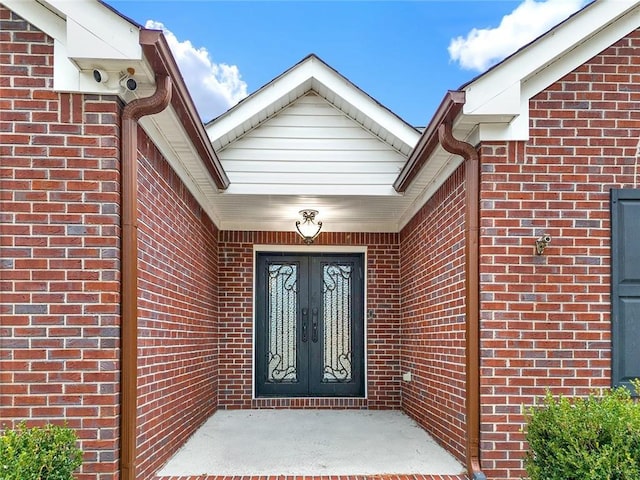 doorway to property featuring brick siding and french doors