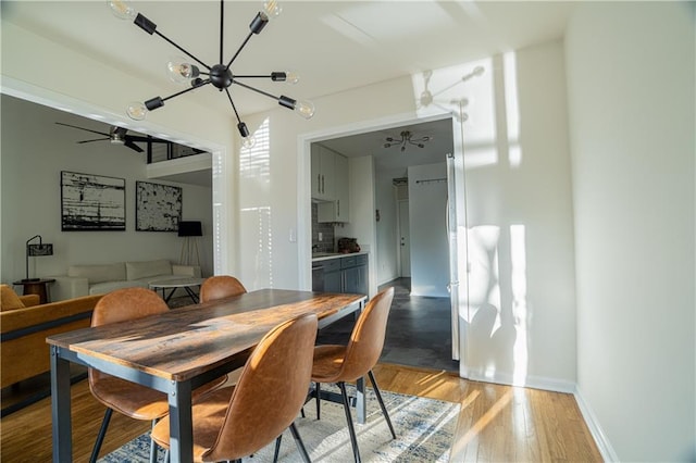 dining space featuring light wood finished floors, a ceiling fan, and baseboards