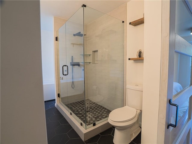 full bath with toilet, a shower stall, and tile patterned flooring