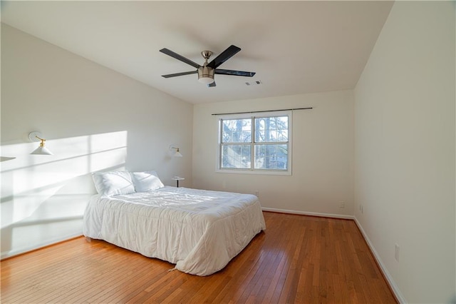 bedroom featuring baseboards, visible vents, ceiling fan, and hardwood / wood-style floors