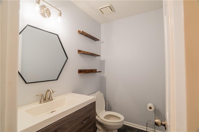 bathroom featuring vanity, toilet, and baseboards