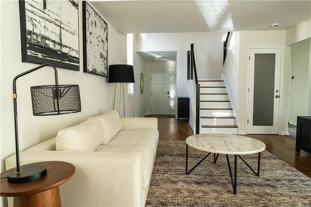 living area with stairs, dark wood finished floors, and baseboards