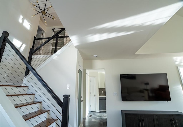 stairway featuring a towering ceiling and a chandelier