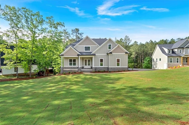 craftsman-style home with board and batten siding, a front lawn, and french doors