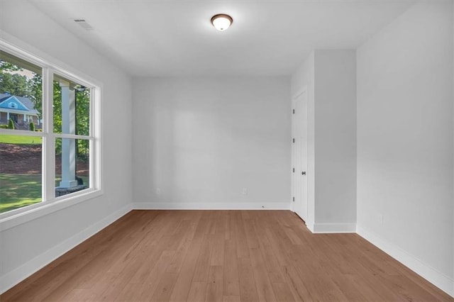 unfurnished room with light wood-style flooring and baseboards