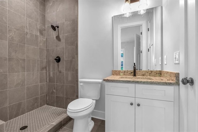 full bath with tiled shower, toilet, vanity, and baseboards