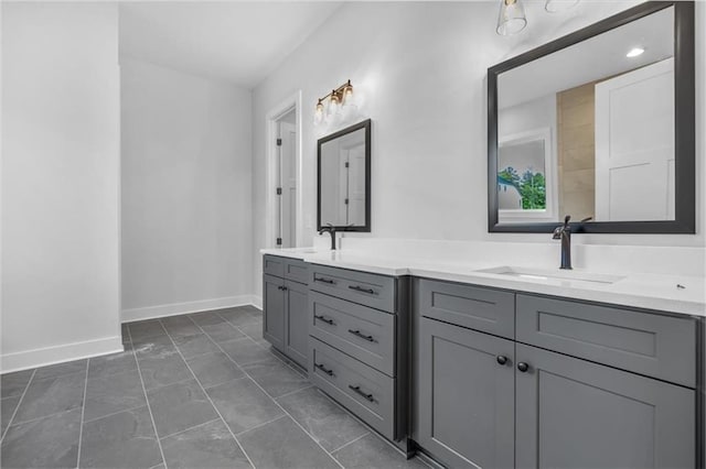 bathroom with marble finish flooring, double vanity, and baseboards