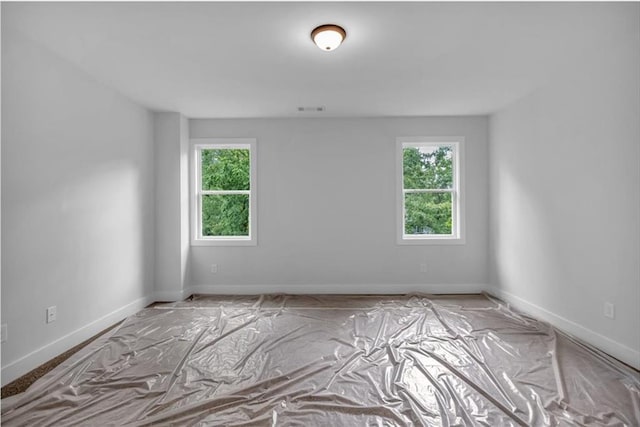 unfurnished room featuring healthy amount of natural light and baseboards