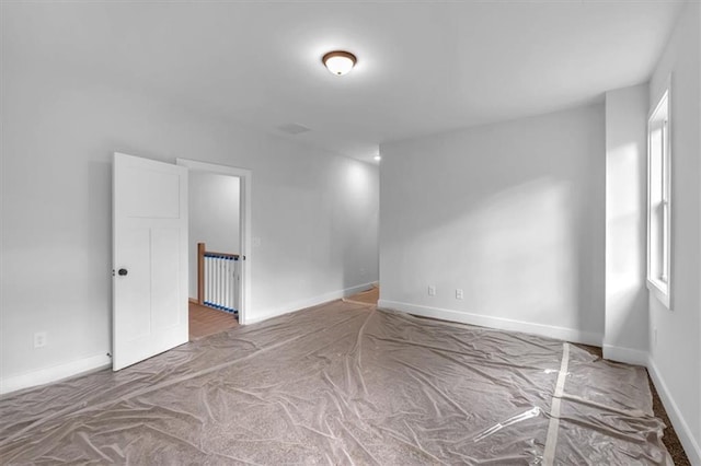 carpeted empty room featuring baseboards