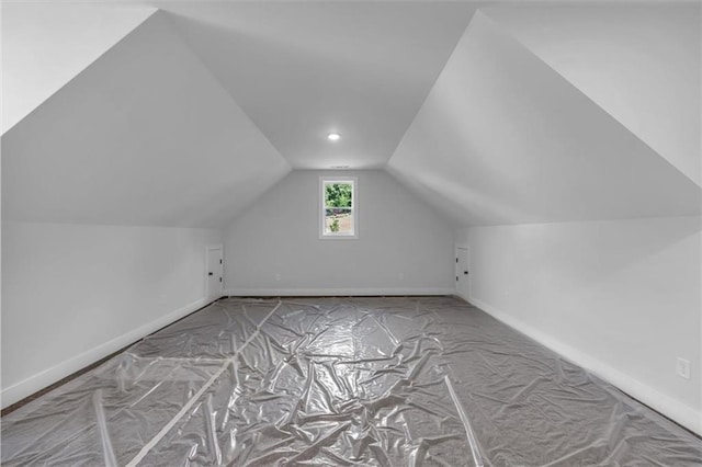 additional living space with baseboards and lofted ceiling