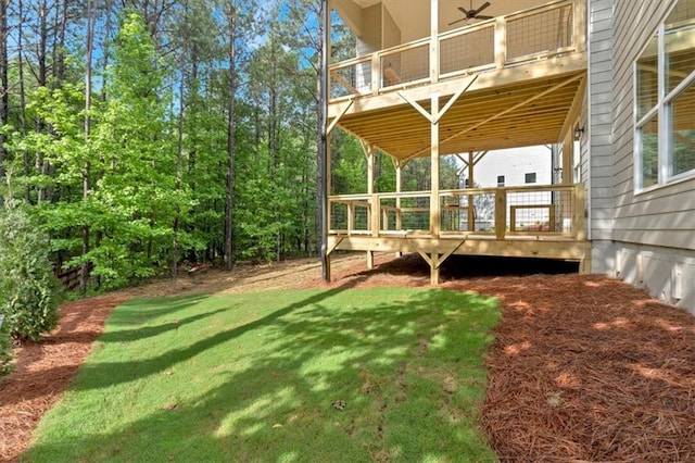 view of green lawn with a deck and a balcony