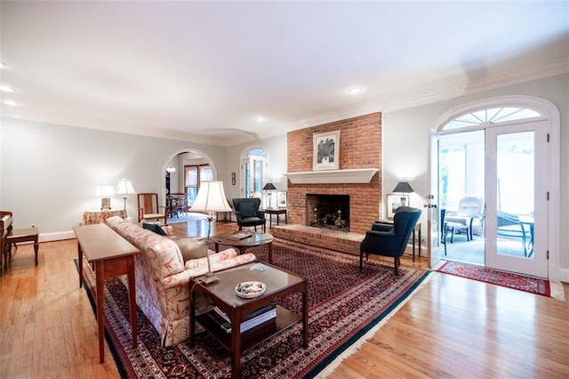 3030 Spalding Dr, Sandy Springs, GA 30350 - living room with arched walkways, light wood-type flooring, ornamental molding, a fireplace, and plenty of natural light