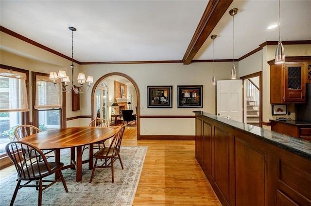 3030 Spalding Dr, Sandy Springs, GA 30350 - dining area with arched walkways, light wood finished floors, a chandelier, stairway, and crown molding