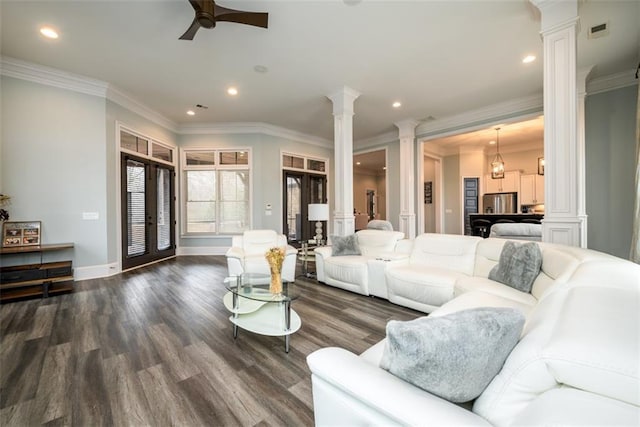 living room with decorative columns, crown molding, dark hardwood / wood-style floors, and ceiling fan