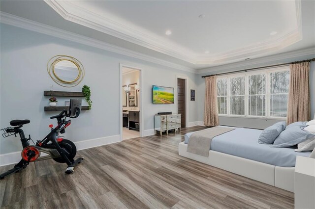 bedroom with ornamental molding, dark hardwood / wood-style flooring, and a raised ceiling