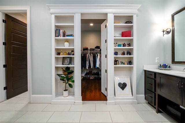 interior space featuring built in shelves, vanity, and tile patterned flooring