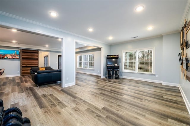 living room with crown molding, hardwood / wood-style flooring, and plenty of natural light