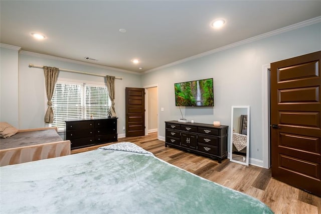 bedroom with crown molding and light wood-type flooring