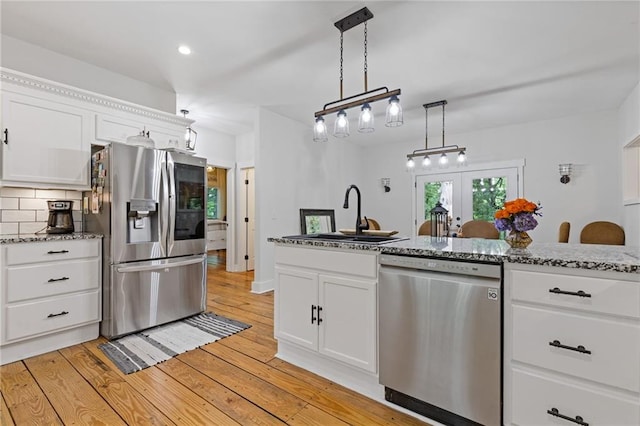 6224 Eagle Ct, Gainesville, GA 30506 - kitchen with stainless steel appliances, a sink, light wood-style flooring, white cabinetry, and french doors