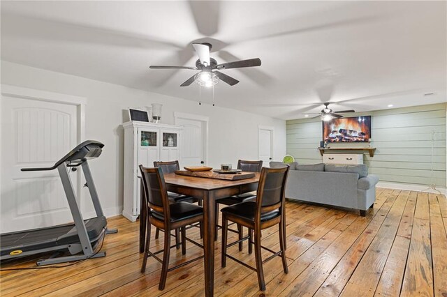 6224 Eagle Ct, Gainesville, GA 30506 - dining room featuring light wood finished floors, a ceiling fan, wood walls, and baseboards