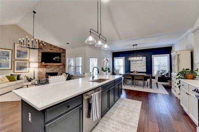 kitchen with a sink, dark wood-style floors, open floor plan, dishwasher, and plenty of natural light