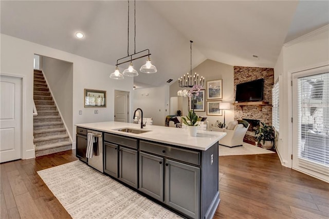 kitchen featuring dark wood finished floors, vaulted ceiling, light countertops, and a sink