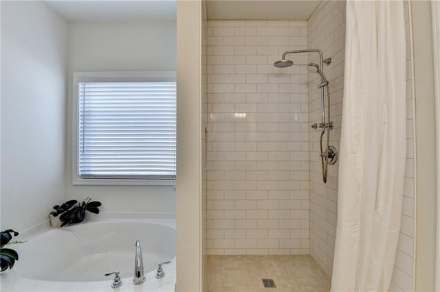 bathroom featuring a shower stall and a bath