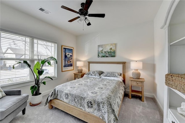 carpeted bedroom with a ceiling fan, visible vents, and baseboards