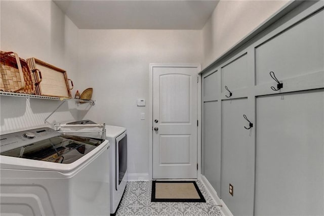 washroom with laundry area, washing machine and dryer, and baseboards