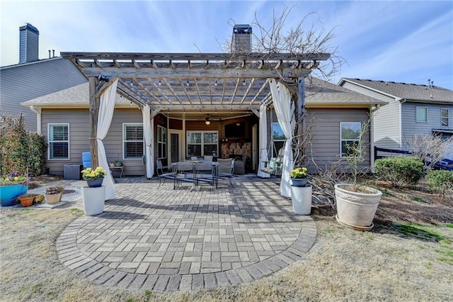 rear view of property featuring ceiling fan, a chimney, a patio area, a pergola, and outdoor dining space