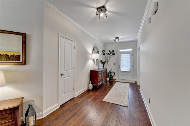 foyer with baseboards, ornamental molding, and dark wood-type flooring