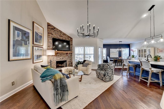 living room featuring wood-type flooring, a fireplace, a chandelier, and a wealth of natural light