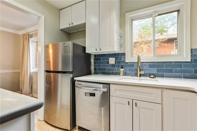 kitchen with decorative backsplash, stainless steel appliances, white cabinetry, and sink