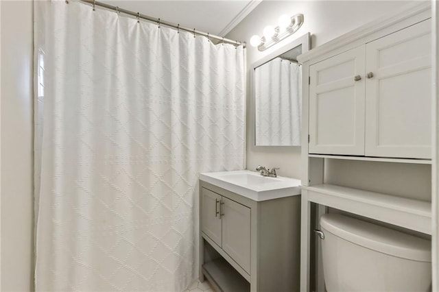 bathroom with crown molding, vanity, and toilet