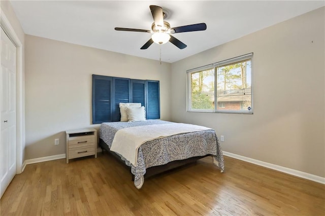 bedroom featuring ceiling fan, light hardwood / wood-style flooring, and a closet